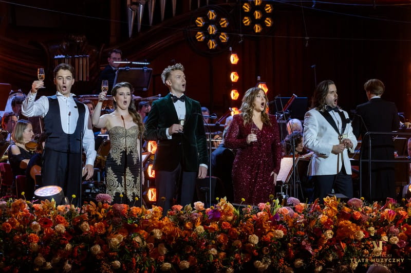 artyści na scenie wznoszą toast