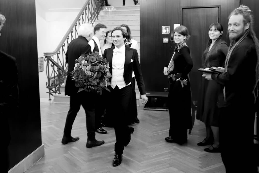 artysta wychodzi z sali z bukietem