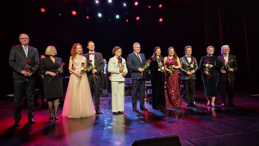 grupa osób z kwiatami na scenie