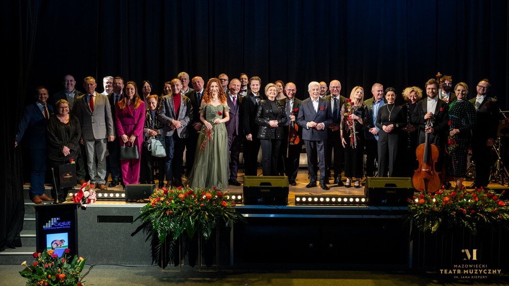 zdjęcie grupowe kilkunastu osób na scenie